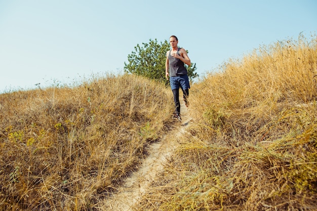 Free photo running sport. man runner sprinting outdoor in scenic nature. fit muscular male athlete training trail running for marathon run.