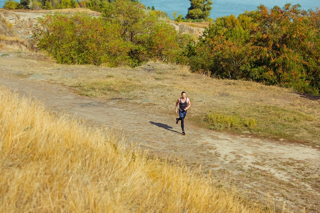 Free photo running sport. man runner sprinting outdoor in scenic nature.