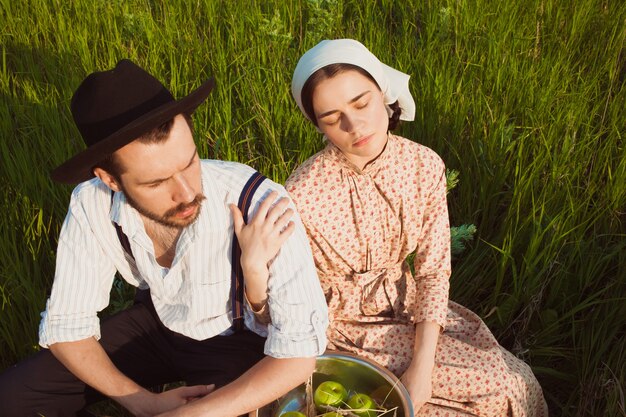 Rural couple sitting in field