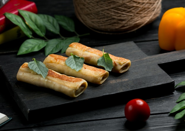 Free photo russian blinchik crepes with oregano leaves and tomato