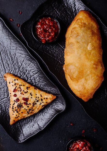 Russian pirojki varieties on a black platter.