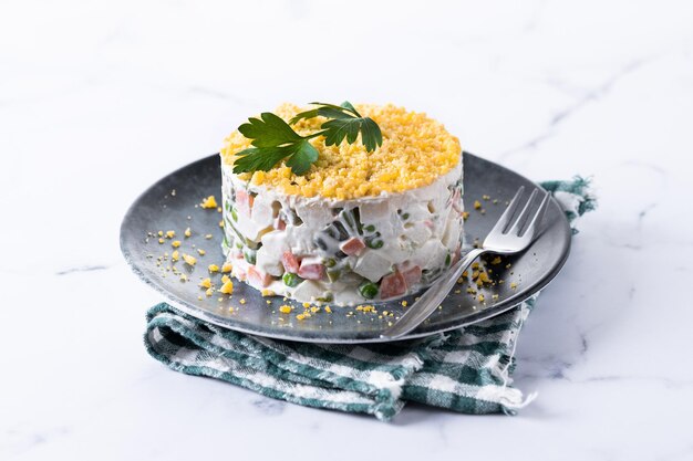 Russian salad or Olivier salad for Christmas dinner on marble background