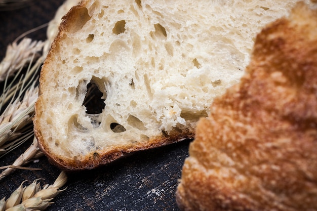 Rustic bread on wood table. Dark wooden background