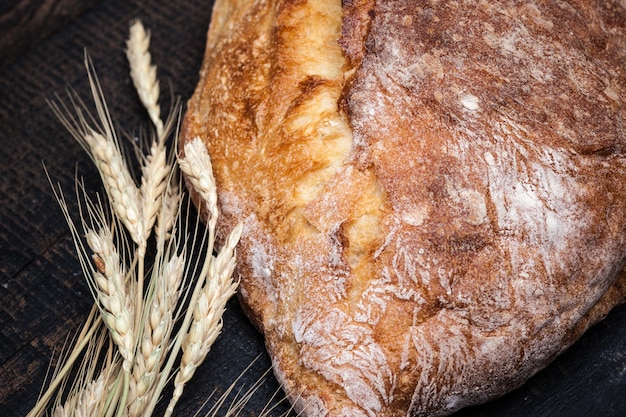 Free photo rustic bread on wood table. dark wooden space