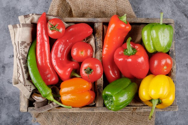 A rustic tray full of color bell peppers. Top view.