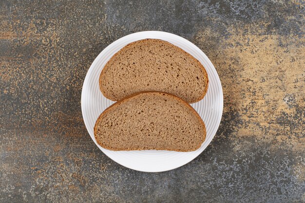 Rye bread slices on white plate.