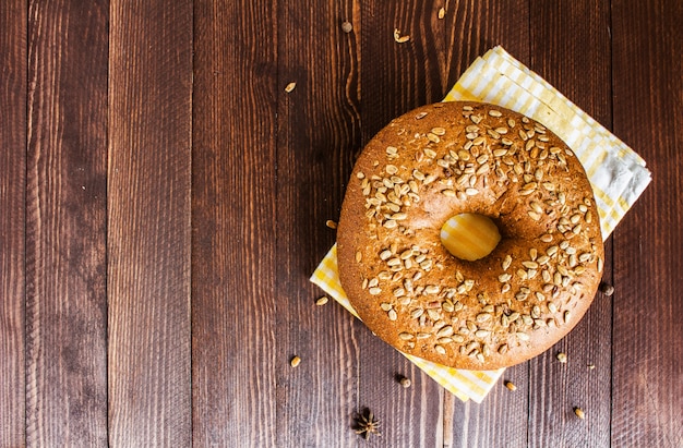 Rye bread with sunflower seeds on towel on wood board