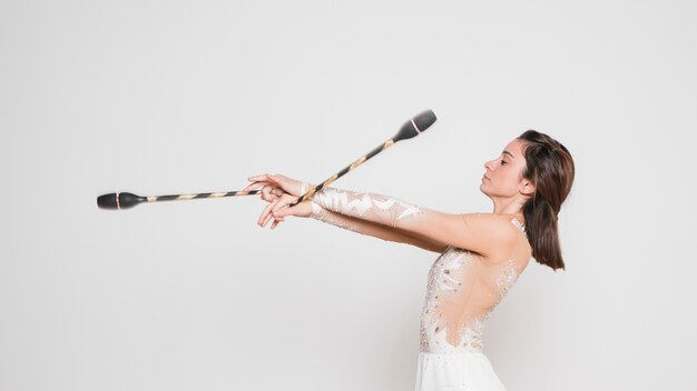 Rythmic gymnast posing with the juggling clubs