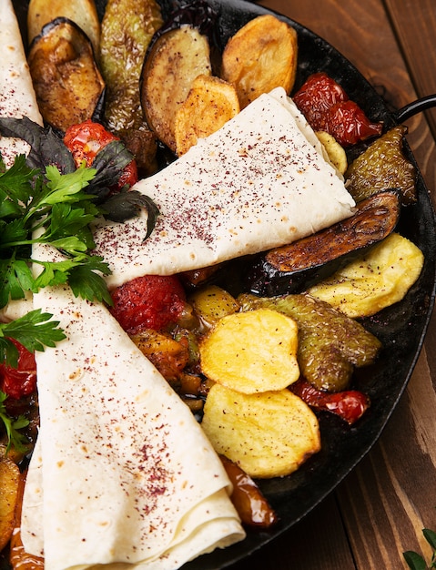 Sac ici, traditional caucasian meal with fried meat and vegetables served with lavash