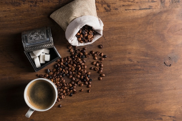 Free photo sack with coffee beans near box for sugar and cup