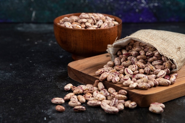 Free photo sackcloth of dried raw beans placed on dark surface.