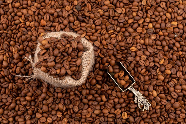 sackcloth full of coffee beans on coffee beans surface