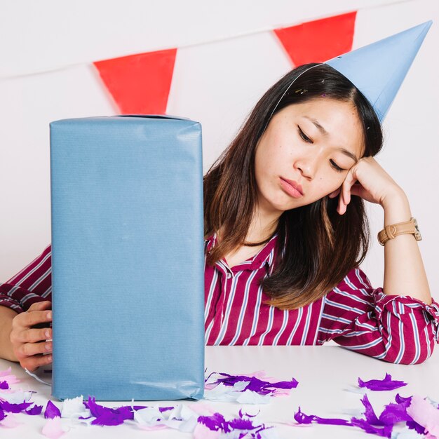 Sad birthday girl with present box