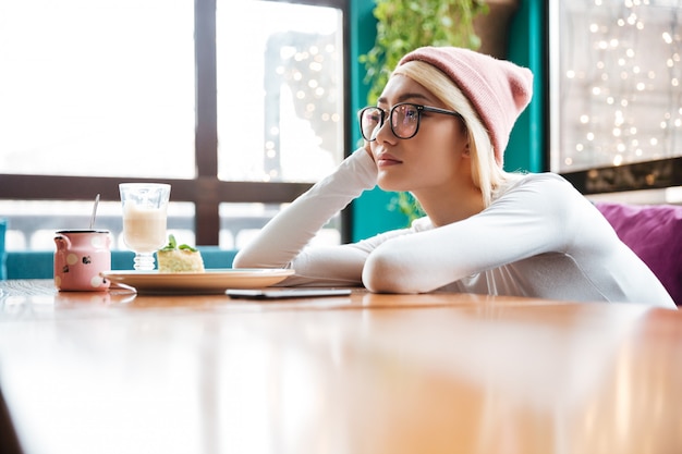 Free Photo sad bored young woman sitting at the table in cafe