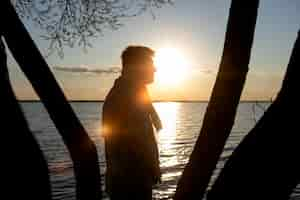 Free photo sad and contemplative person near lake