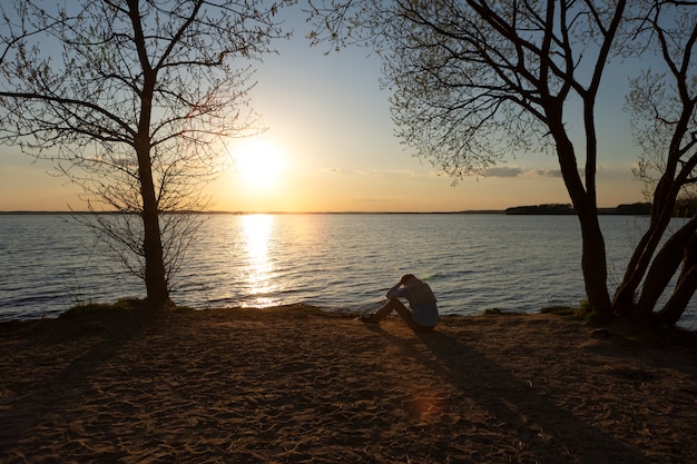 Free photo sad and contemplative person near lake