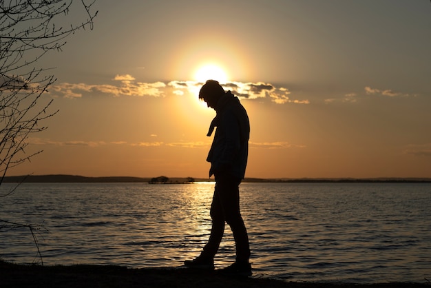 Sad and contemplative person near lake