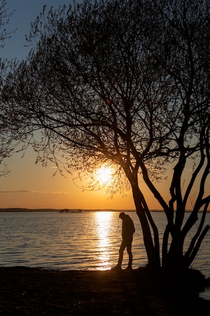 Free photo sad and contemplative person near lake