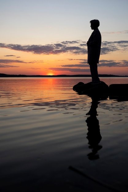 Sad and contemplative person near lake