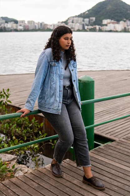 Free Photo sad and contemplative woman sitting by the lake