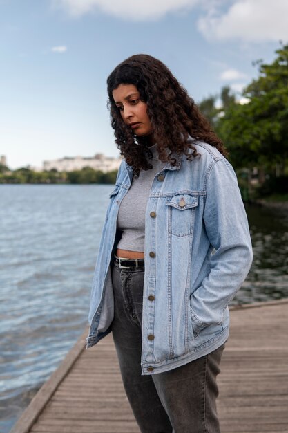 Free Photo sad and contemplative woman sitting by the lake