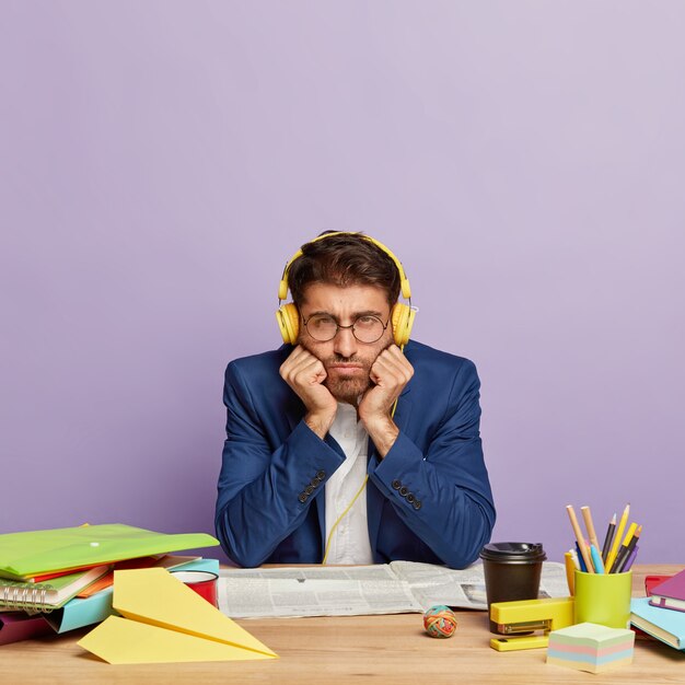 Sad displeased businessman sitting at the office desk