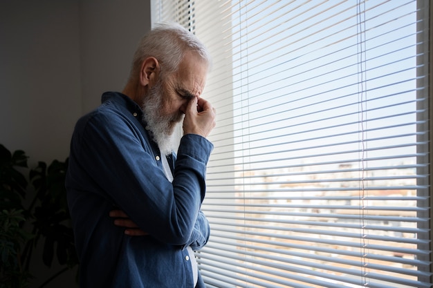 Free photo sad elder man at home