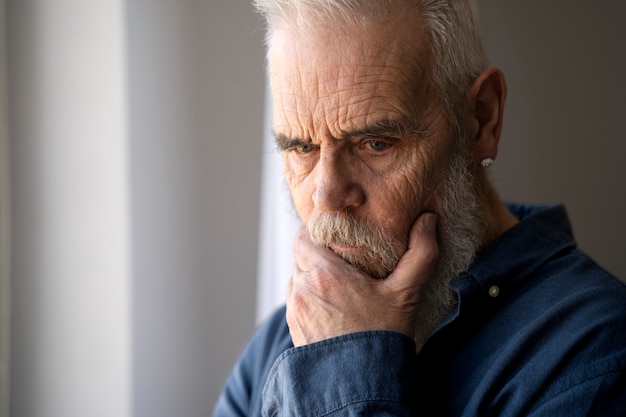 Free photo sad elder man at home