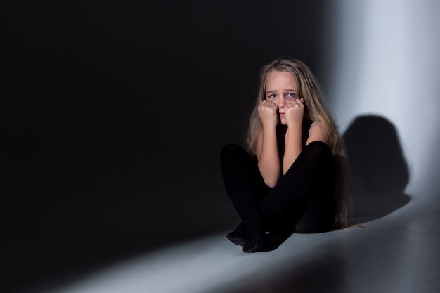 Free photo sad and frightened little girl with bloodshot, bruised eyes crying scared.