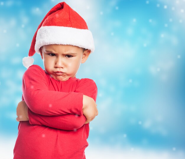 Sad little boy wearing santa hat