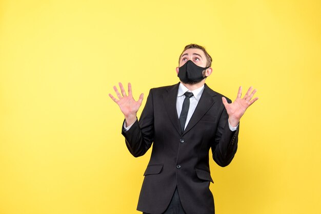 Sad man looking up with anxiety and thinking over yellow