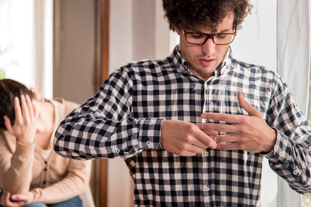 Sad man pulling out wedding ring