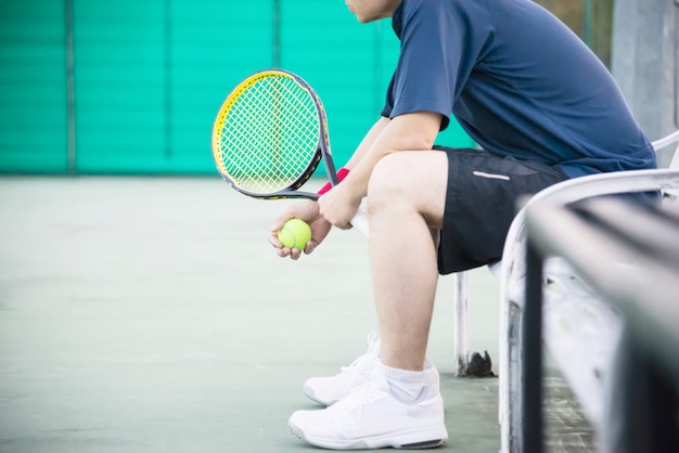 Sad tennis player sitting in the court after lose a match