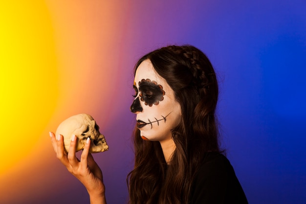 Free photo sad witch looking at skull