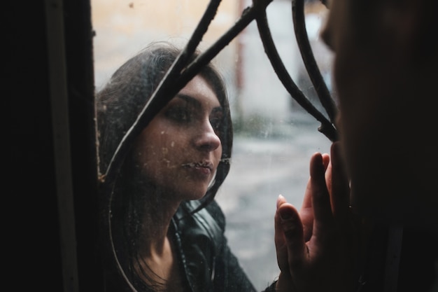 Sad woman looking at her boyfriend through a glass