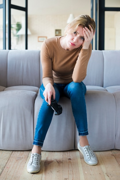 Free Photo sad woman sitting with joystick on couch 