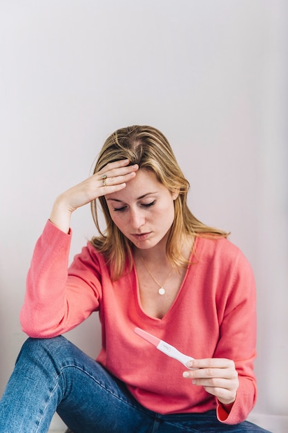 Free photo sad woman with pregnancy test