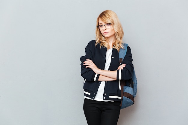 Free photo sad young lady student wearing glasses with backpack