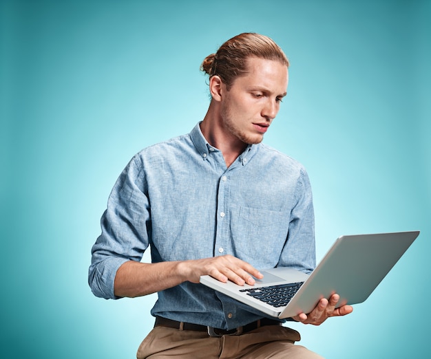 Free photo sad young man working on laptop