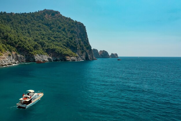 Sailboat in the sea in the evening sunlight over beautiful big mountains, luxury summer adventure, active vacation in Mediterranean sea, Turkey