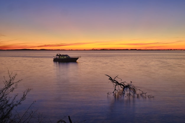 Free Photo sailing boat on the calm beautiful ocean with the breathtaking sunset 