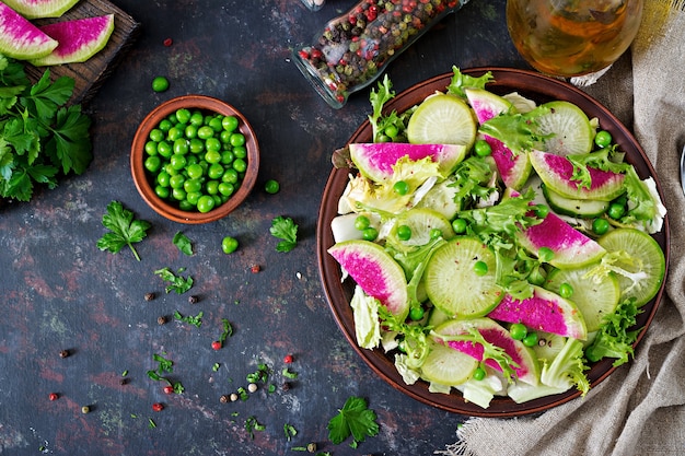 Salad from radish, cucumber and lettuce leaves. Vegan food. Dietary menu. Top view. Flat lay