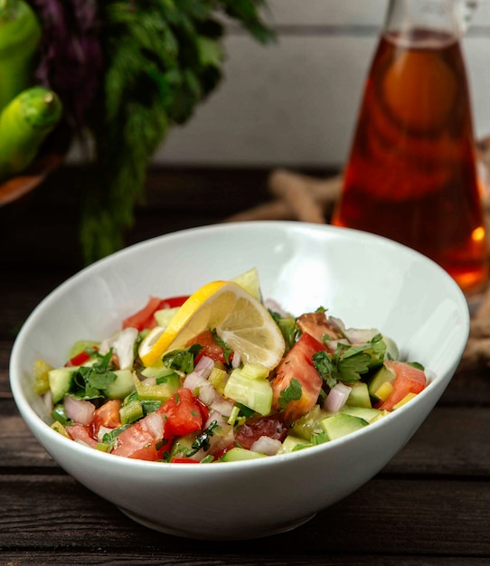 Salad of tomatoes cucumbers onions and greens on a table