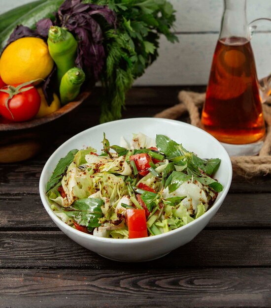 Salad of tomatoes lettuce and soy sauce on the table