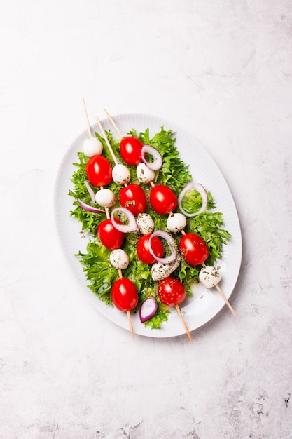 Free photo salad with cheese and tomato skewers