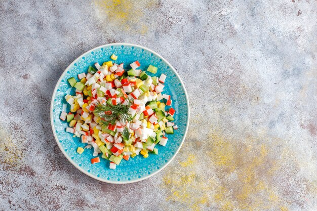 Salad with crab sticks, eggs, corn and cucumber.