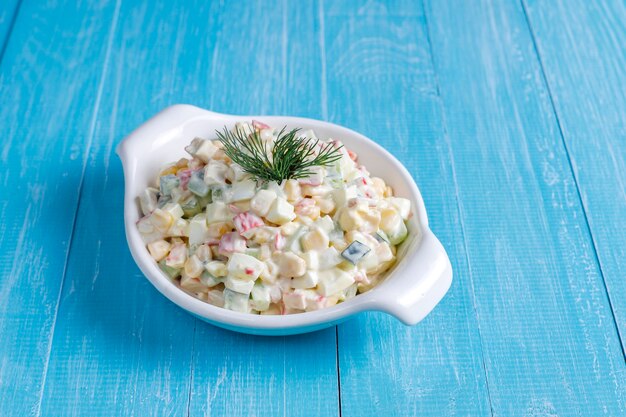 Salad with crab sticks, eggs, corn and cucumber.