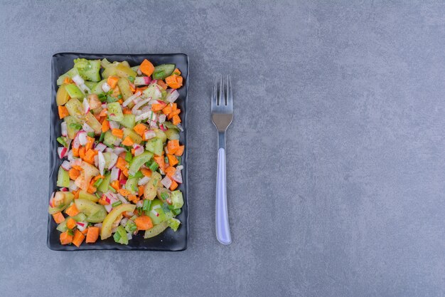 Salad with seasonal herbs and vegetables in a platter