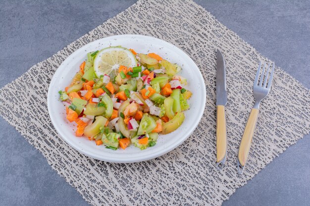 Salad with seasonal herbs and vegetables in a platter