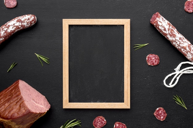 Salami and fillet meat with frame on desk